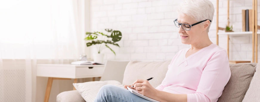 Life Assure Senior Woman Writing A List Seated At Home Blog